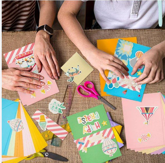 Two people making colorful handmade greeting cards