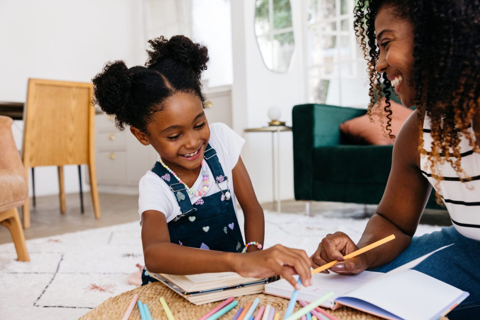 Mother and daughter drawing together on floor